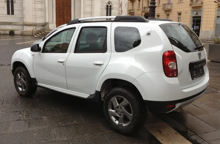 SUV blanc garé devant un bâtiment ancien.