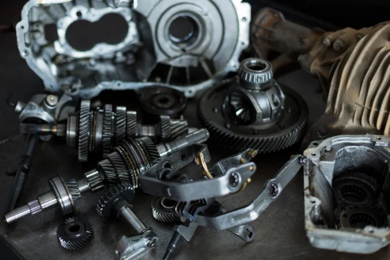 Pièces de transmission automobile éparpillées sur une surface métallique.