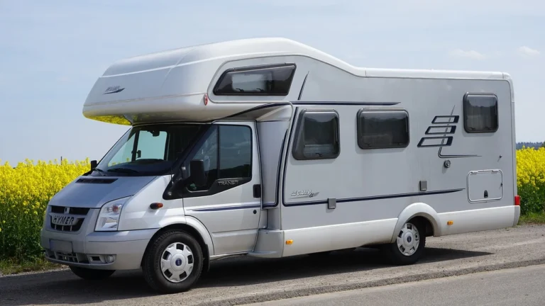 Camping-car stationné près d'un champ de colza en fleurs.