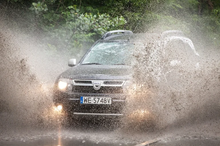 SUV traversant une flaque d'eau, éclaboussures importantes.