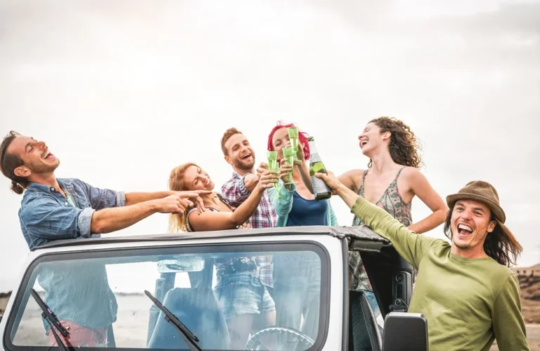 Groupe d'amis célébrant dans un cabriolet en plein air.