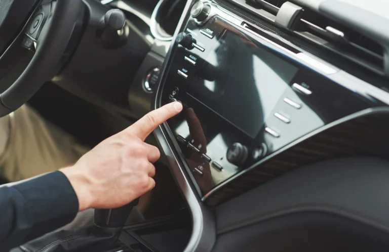 Un homme utilise l'écran tactile du tableau de bord d'une voiture.