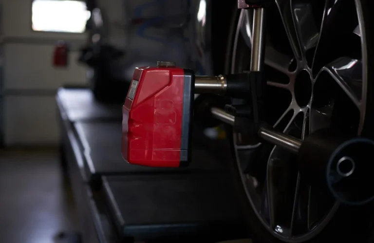 Appareil d'alignement sur une roue de voiture dans un garage sombre.